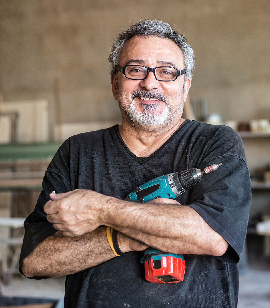 self employed person holding a drill